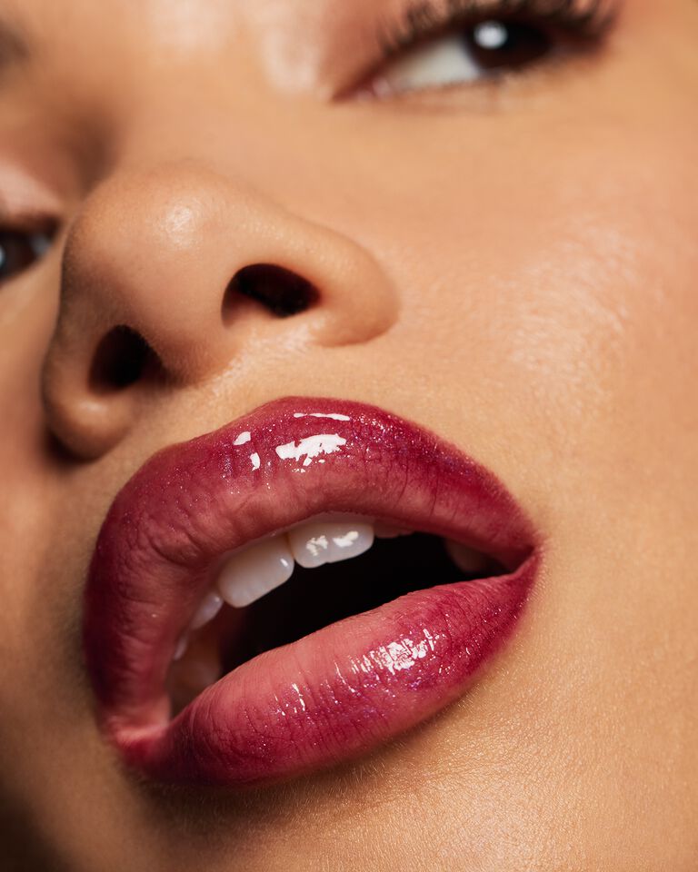 Nahaufnahme der Lippen einer Frau: ultra gl&auml;nzend und mit unterschiedlichen Lipgloss Farben geschminkt (Glass Lips)